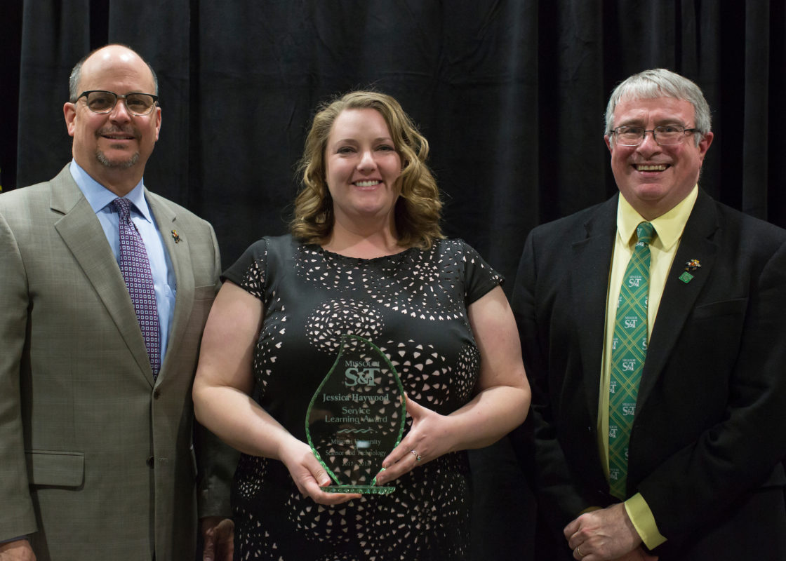 Jessica Haywood, program administrator for volunteerism and involvement, receives the Staff Service Learning Award. From left, Provost Robert Marley, Haywood and Interim Chancellor Christopher Maples.