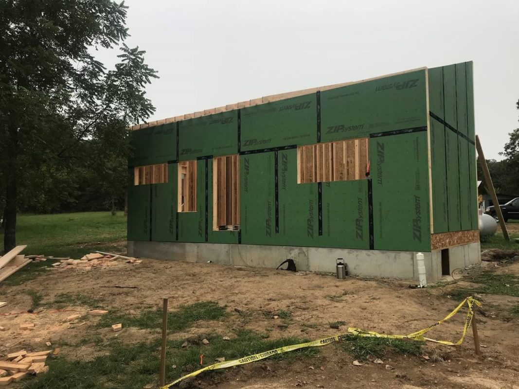 Foundation and walls of tiny home, holes for windows and doors