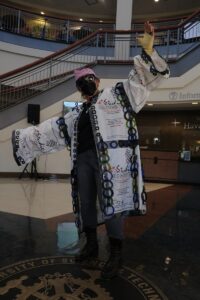Professor modeling fashion design made from recyclables.