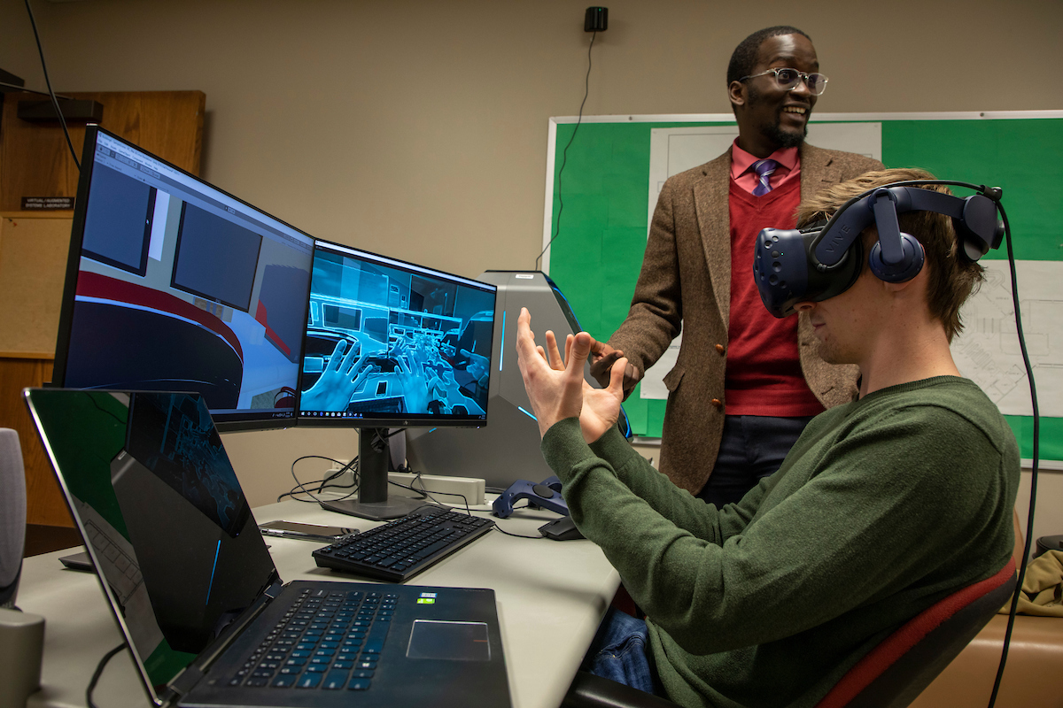 Student using virtual reality device with instructor and computer screens