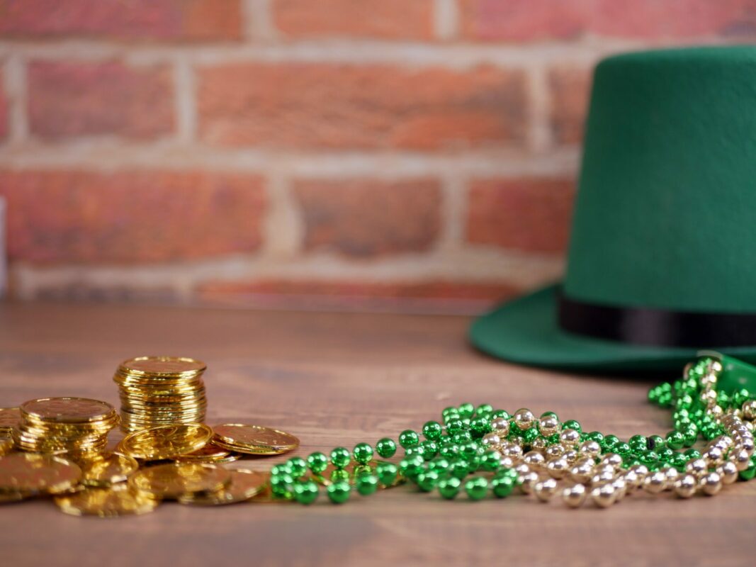 Green top hat with beads and stack of coins.