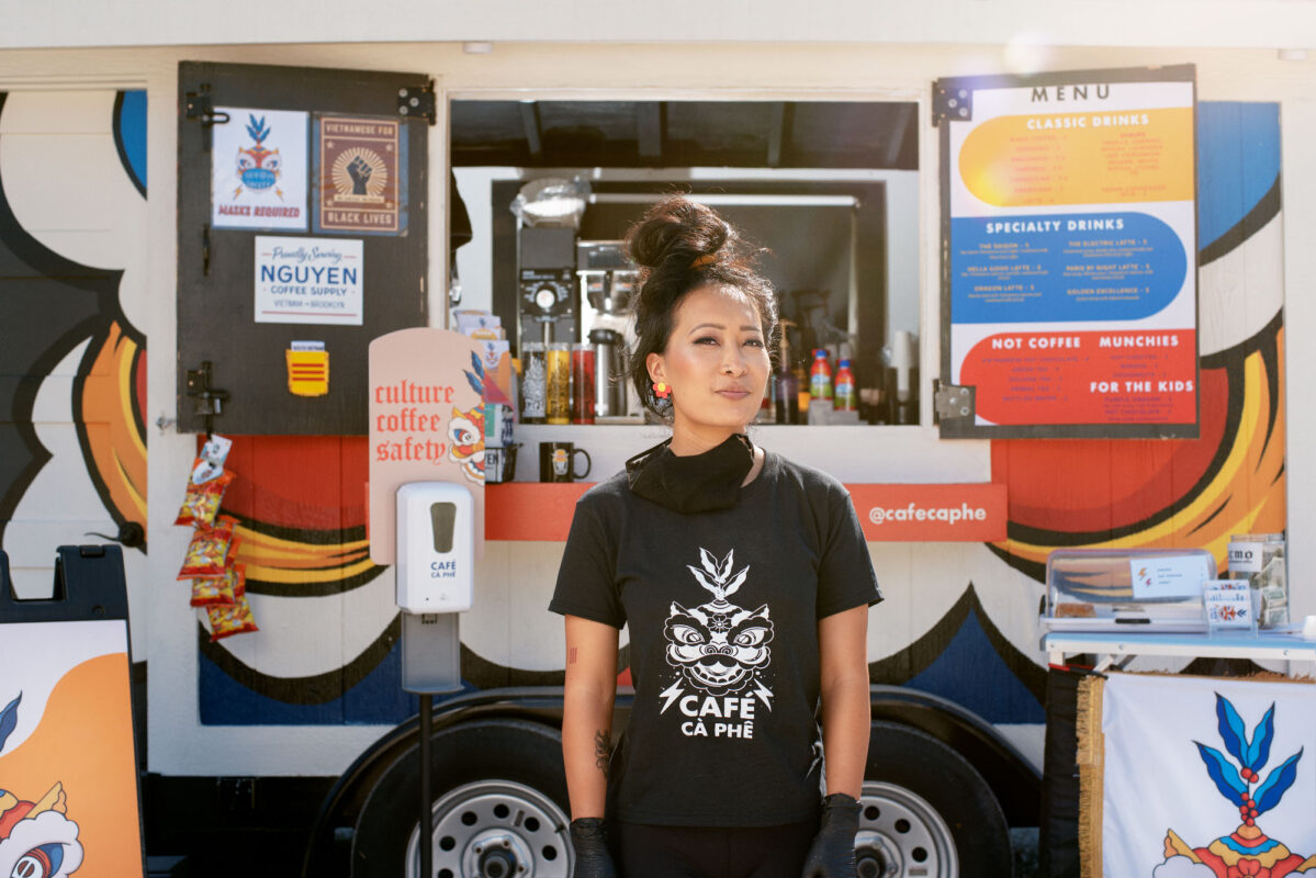 Woman standing in front of a coffee shop trailer.