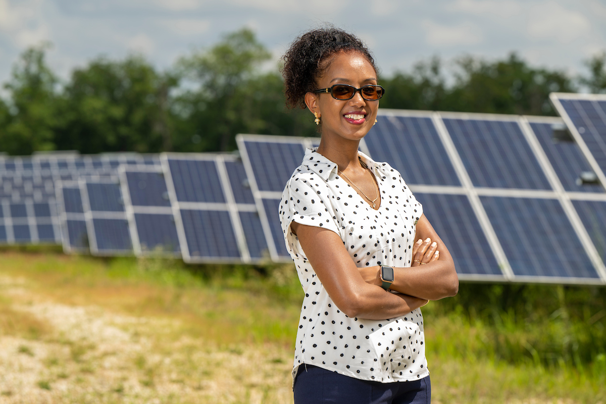 Woman posing in front of solar panels