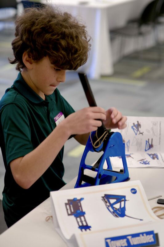 Child assembling one of the prototypes of the Miner Creativity Challegne 2023. Photo Credit: Joseph Nguyen.