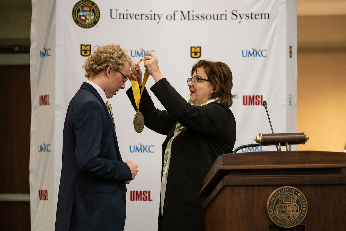 Student receives medal.