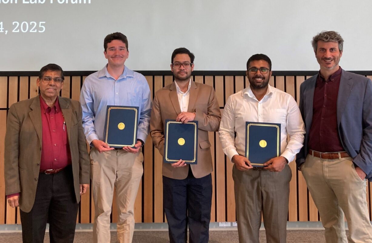 Five men smiling with three holding a certificate folder.