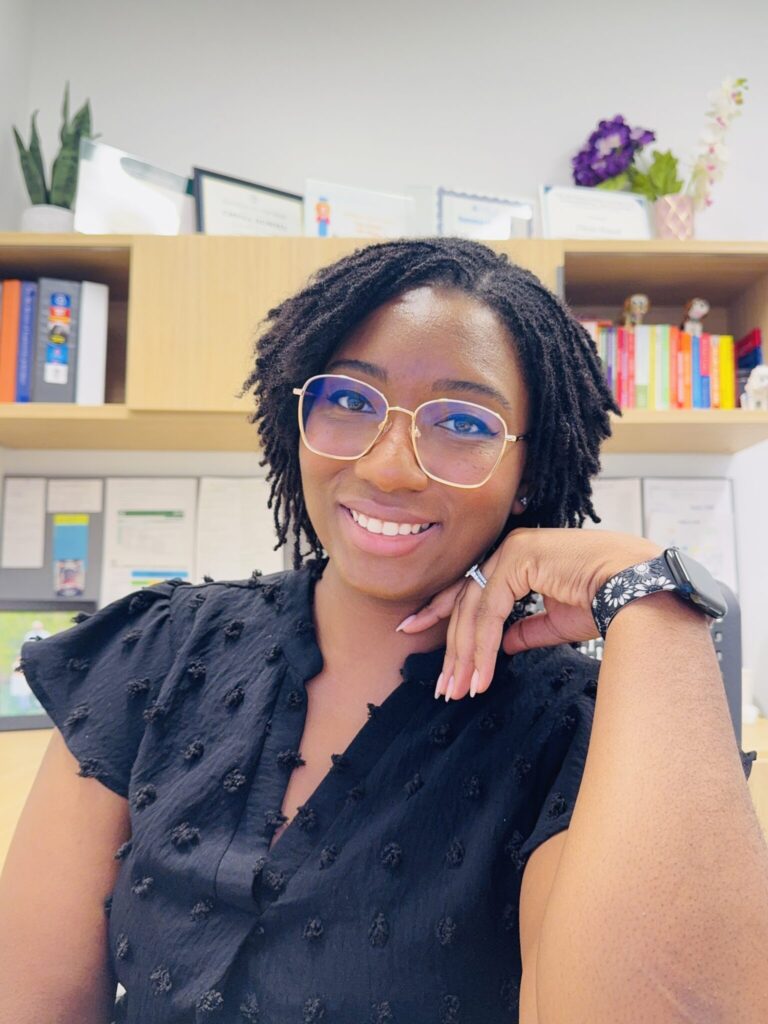 Chyna Howell sitting at her desk, with a warm smile.