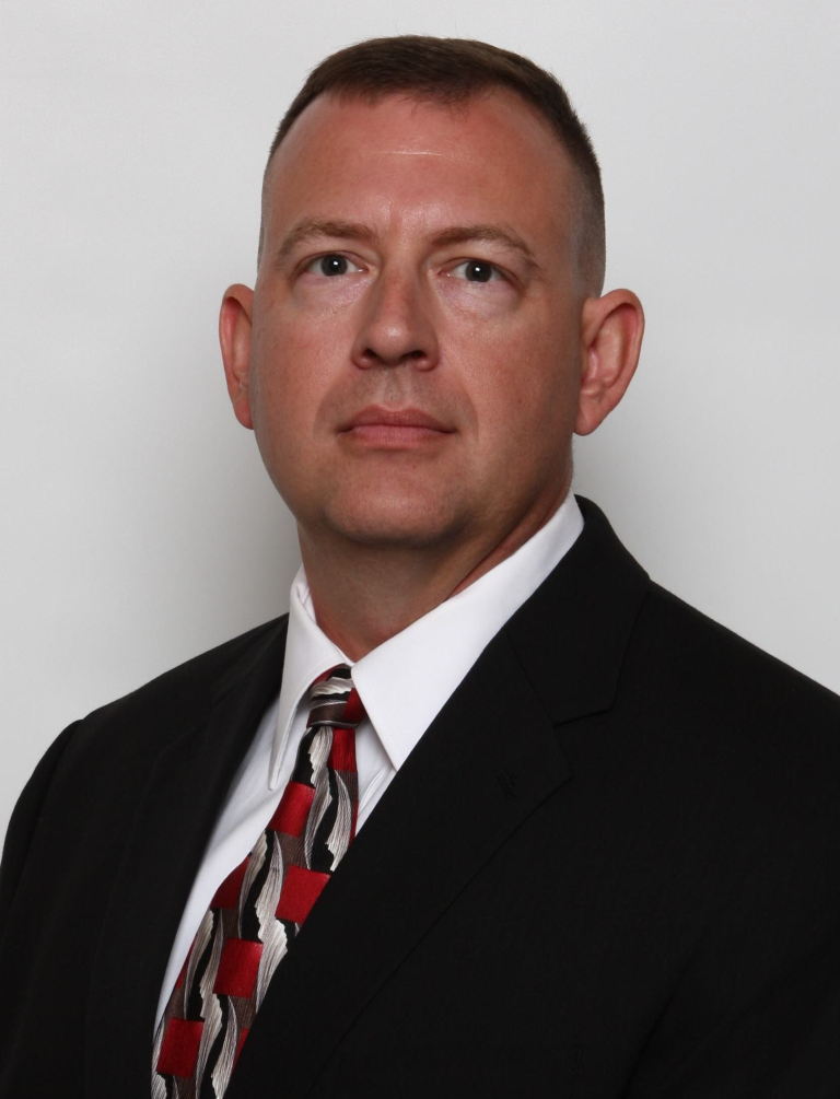 A headshot of a man wearing a suit and tie.