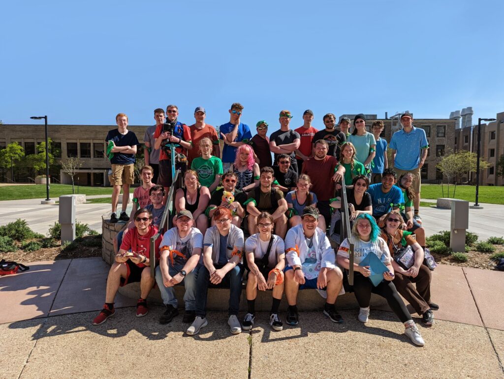 A group of students with bandanas wrapped around their arms pose for a photo on the Puck.