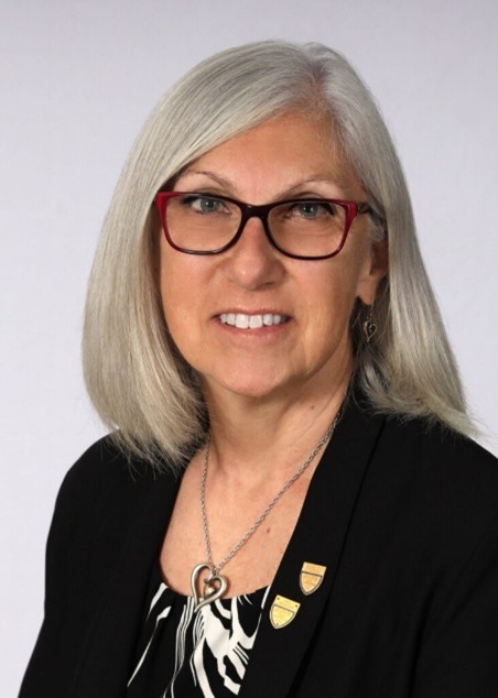 Headshot of Dr. Marsha Anderson Bomar, wearing glasses, a black jacket and a necklace with a heart.