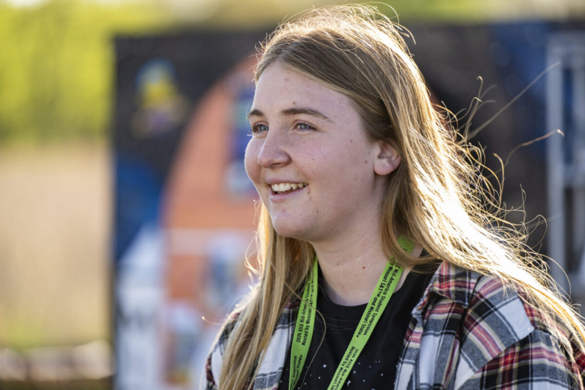 A woman with long hair smiling off to the side.