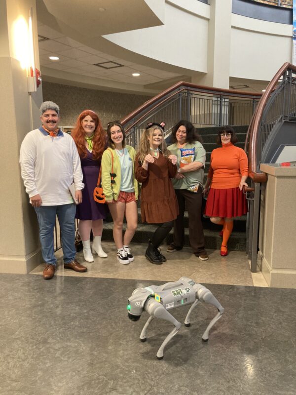 Six people dress up in costumes as the Scooby-Doo gang.