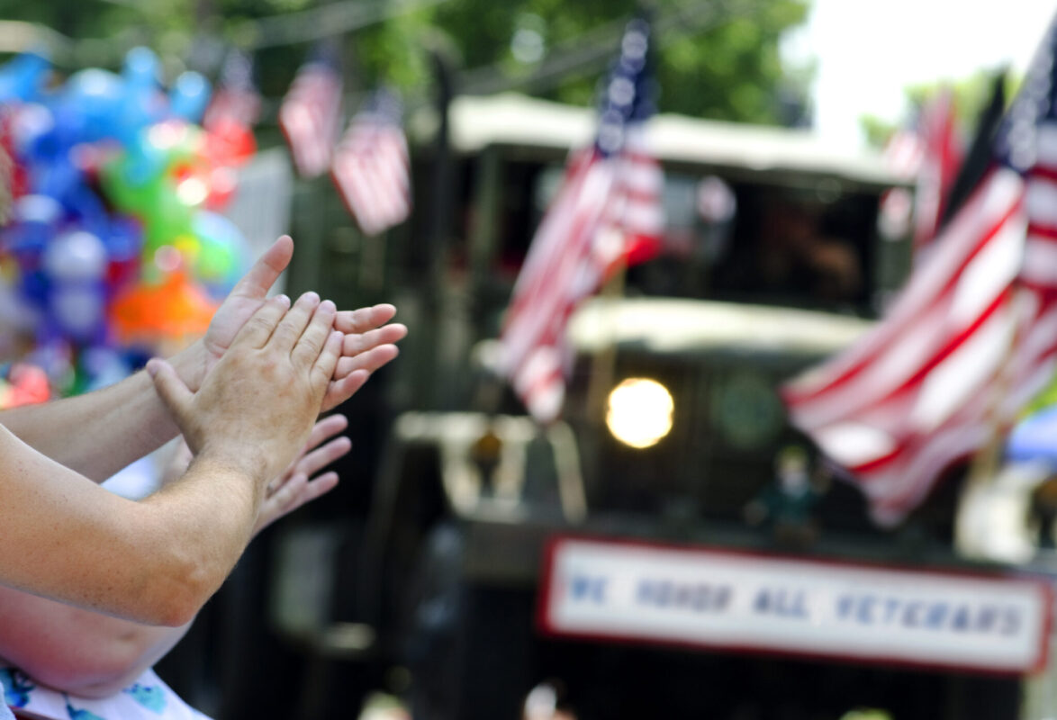 Closeup of hands clapping at veterans parade.
