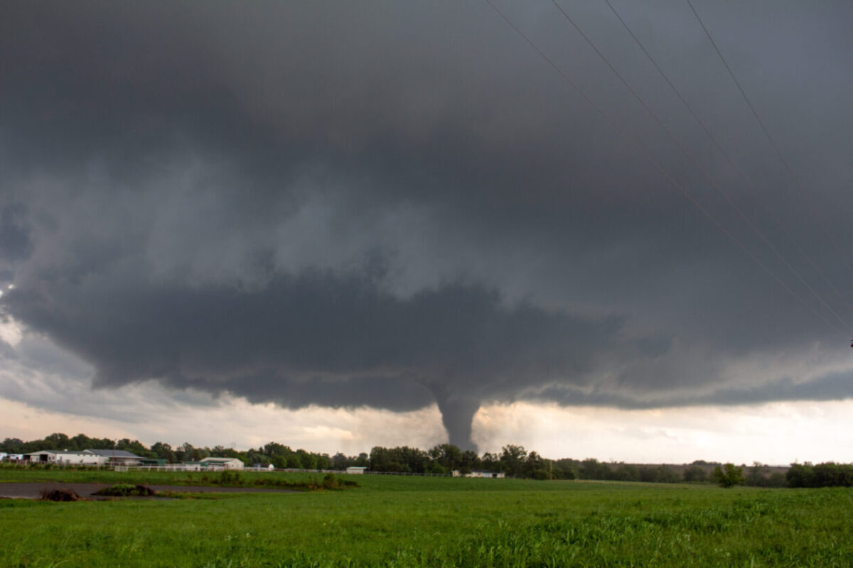 A tornado approaches a farm.