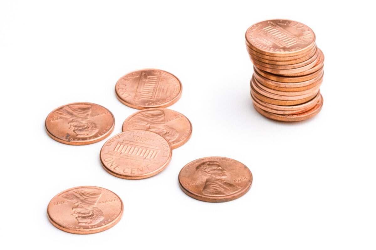A stack of pennies and six pennies laying out of order.