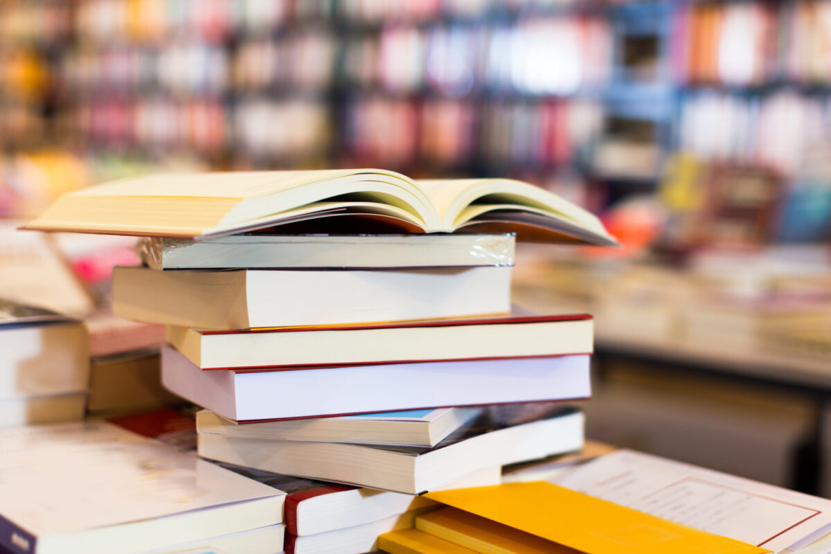 A stack of books lying on table in bookstore.