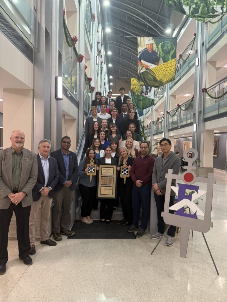 A group of students and faculty pose on a staircase in Butler Carlton Civil Engineering Hall.
