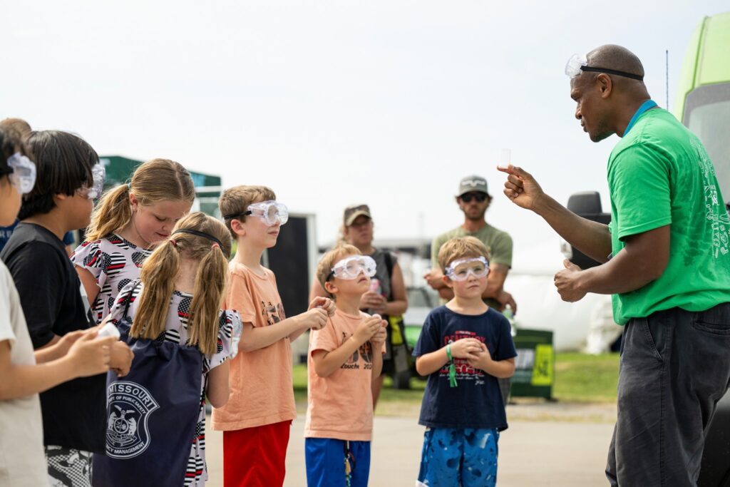 Justin Sanders and children outdoors wearing goggles. 