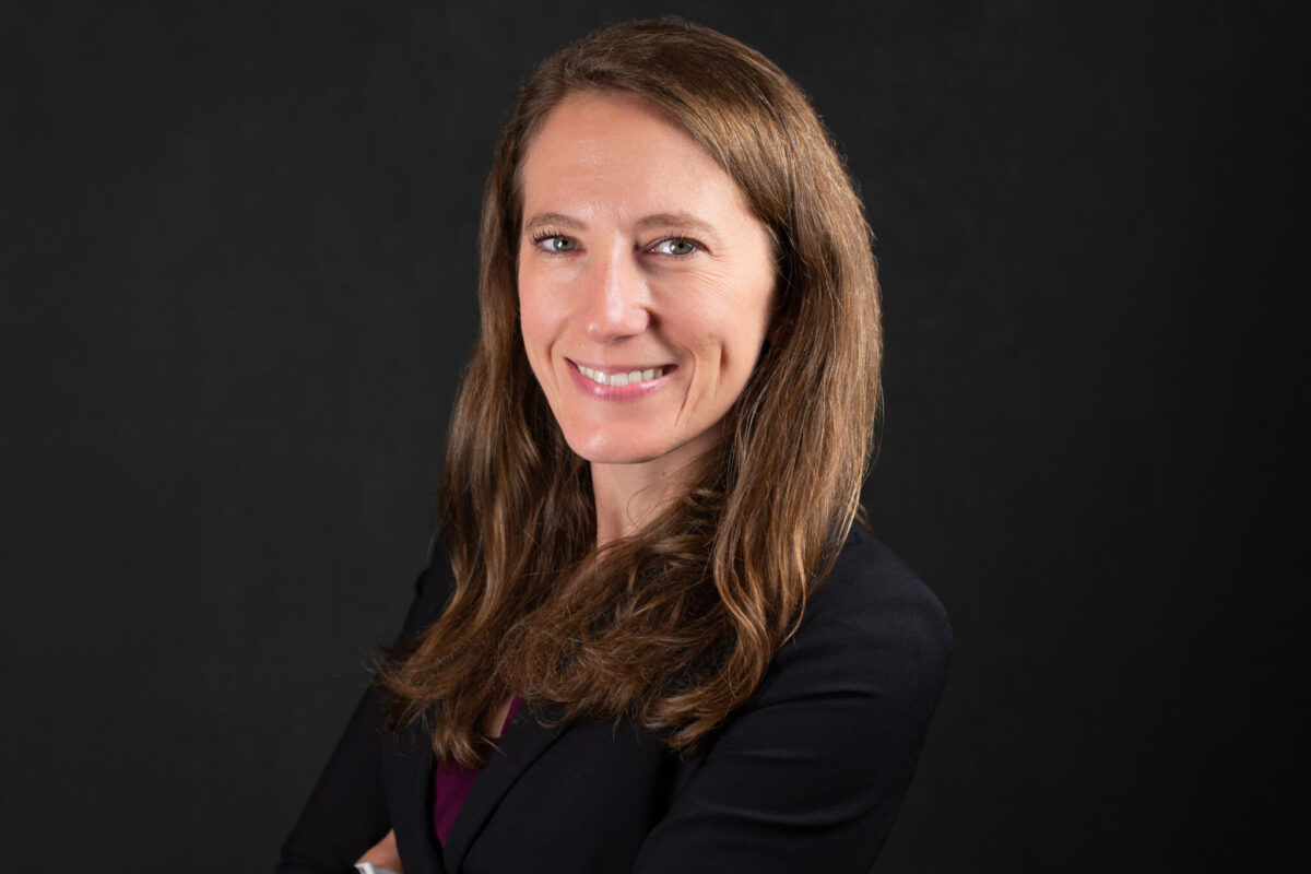 Professional headshot of Dr. Sheppard wearing a black blouse with a black background.