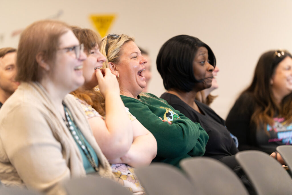 Audience members seated and listening during the Staff Appreciation Day award ceremony.
