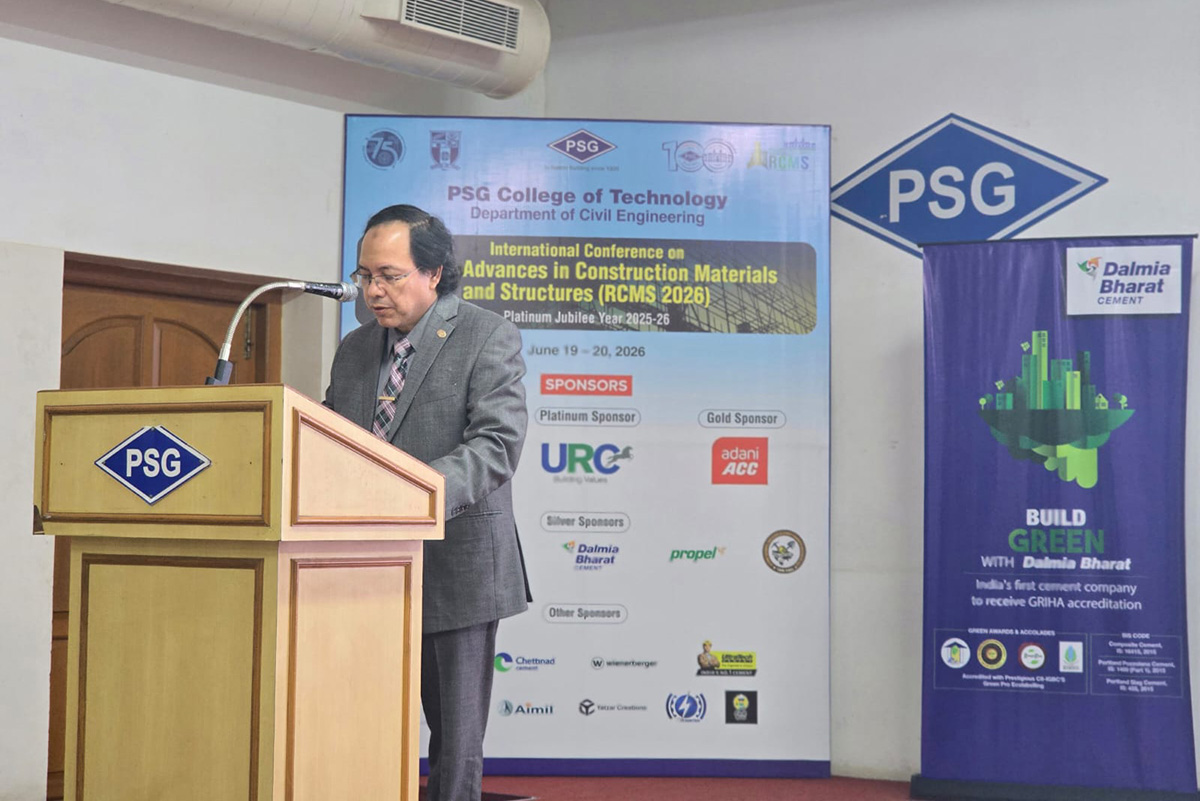 A speaker stands at a podium during RCMS 2026 at PSG College of Technology in India, delivering a keynote presentation on infrastructure resilience and bridge repair research.