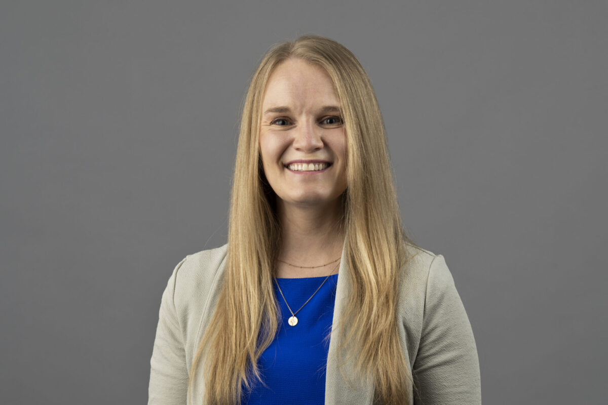 Professional headshot of Dr. Rachel Kohman wearing a light grey blazer and blue shirt with a necklace.