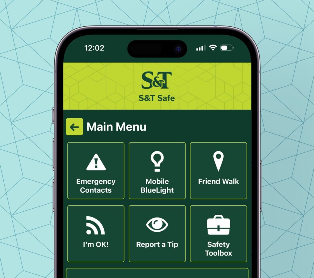 Smartphone displaying the Missouri S&T Safe app main menu. The screen shows six safety features: Emergency Contacts, Mobile BlueLight, Friend Walk, I’m OK!, Report a Tip and Safety Toolbox.